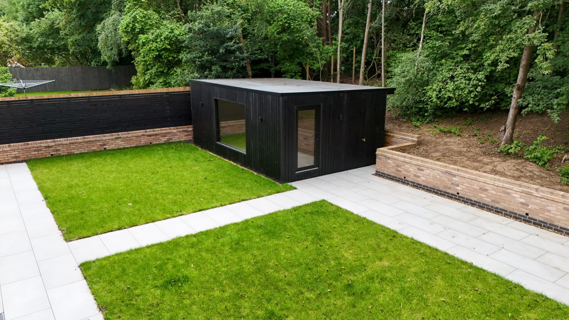 Black clad garden room and home office within a landscaped garden