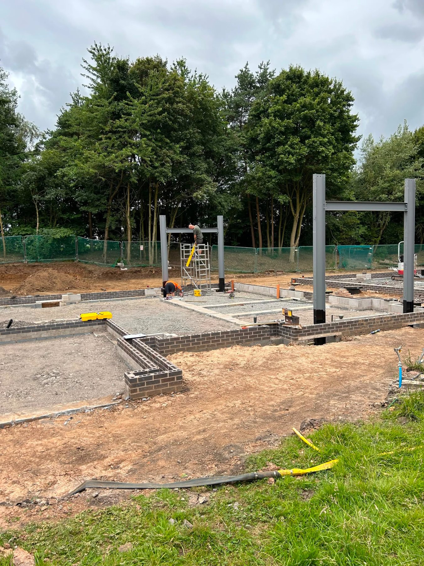 Structural steel columns being set into the foundations of a bespoke home