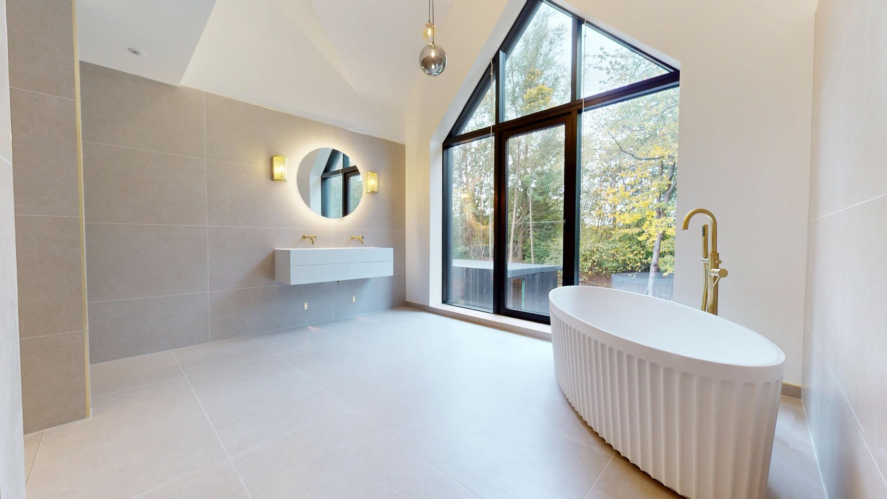 Freestanding bath beneath a full-height gable window