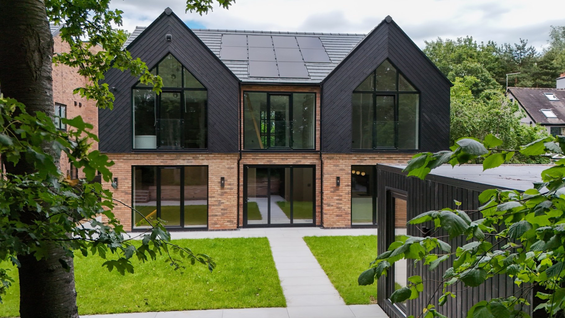 Front elevation of a contemporary brick and black timber gabled five-bedroom home in Horton
