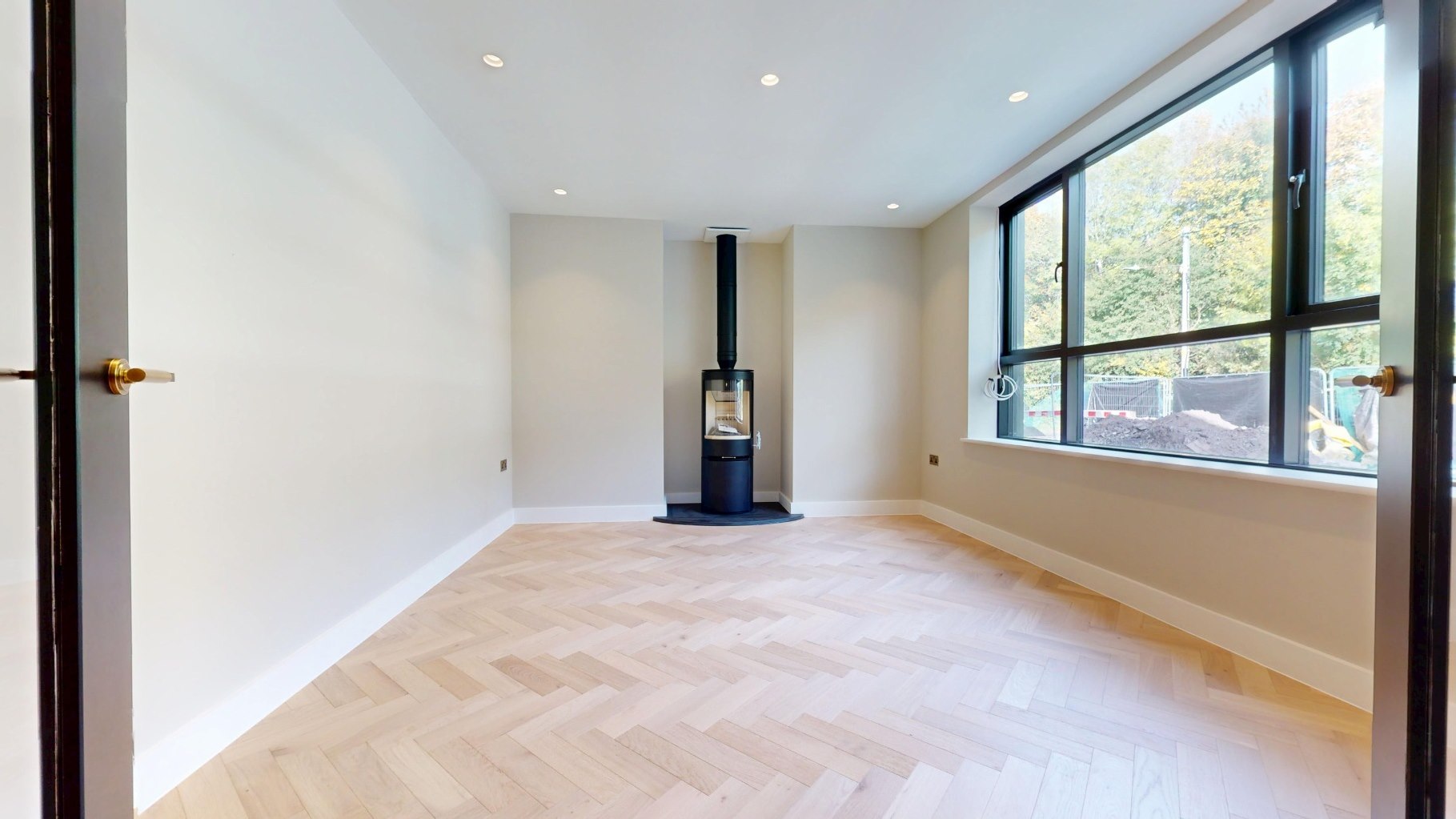 Sitting room with log-burning stove and full-height gable glazing