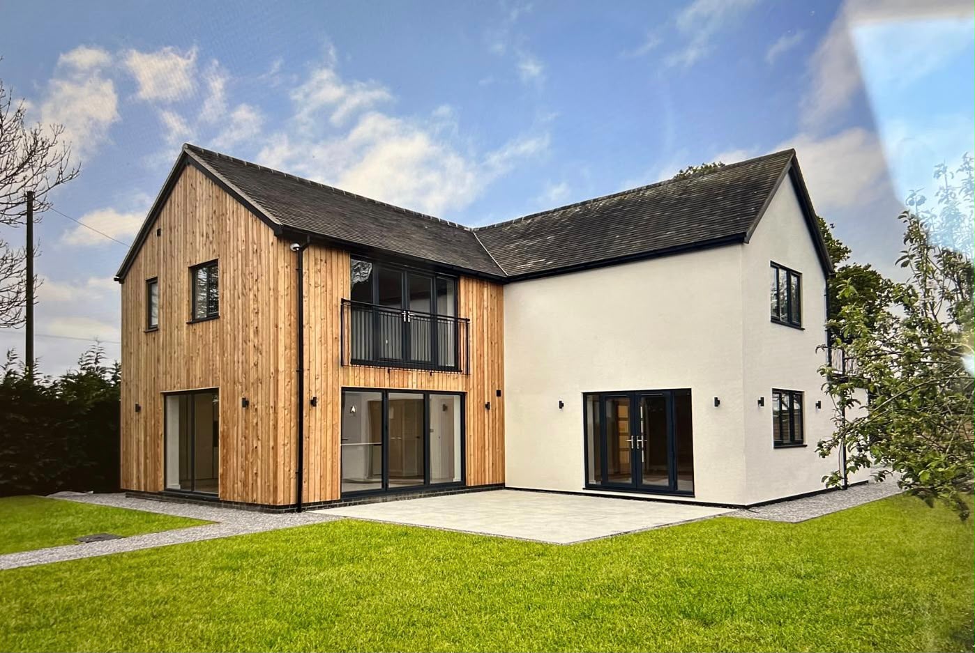 Completed Osbaston Cottage with timber clad extension and landscaped lawn