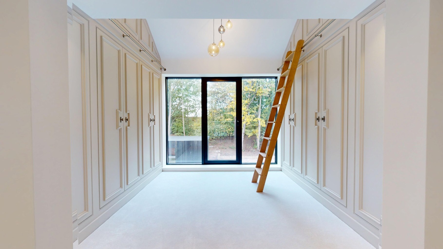 Bespoke fitted dressing room with library ladder and panelled joinery