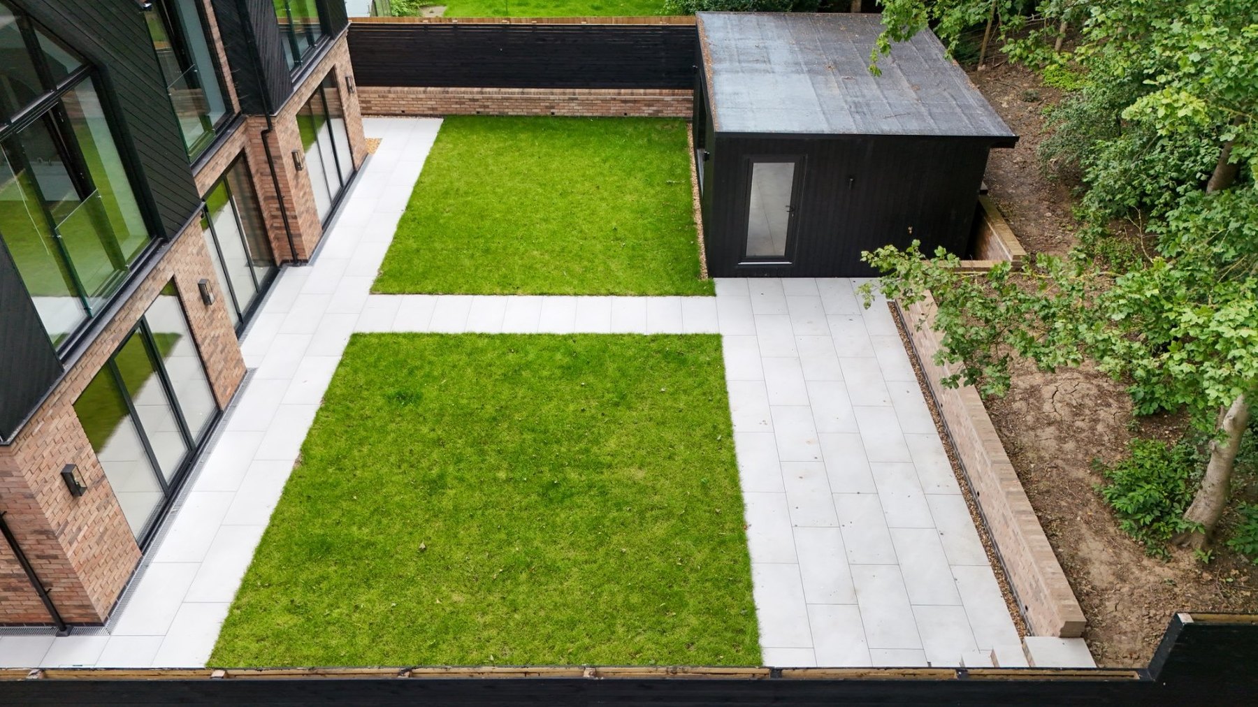 Landscaped rear garden with stone walkways and framed lawns seen from above