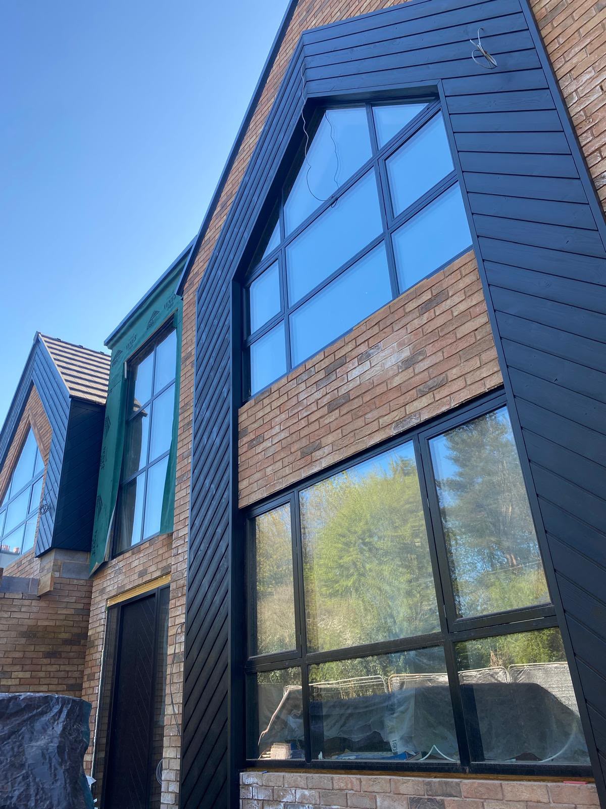 Black timber and brick gables of a bespoke home nearing completion
